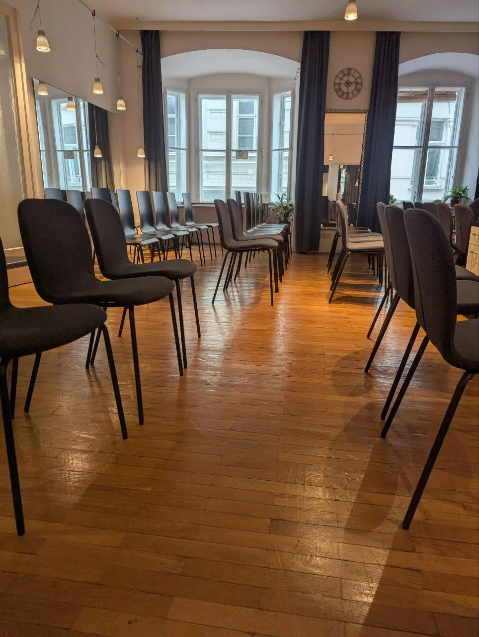 Studioraum mit Kreisbestuhlung, hohen Altbaufenstern und Dielenboden